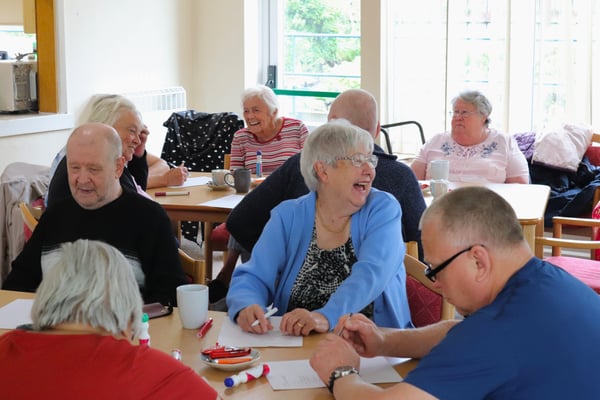 Showing a group of older tenants taking part in socials activities at a CGA sheltered scheme