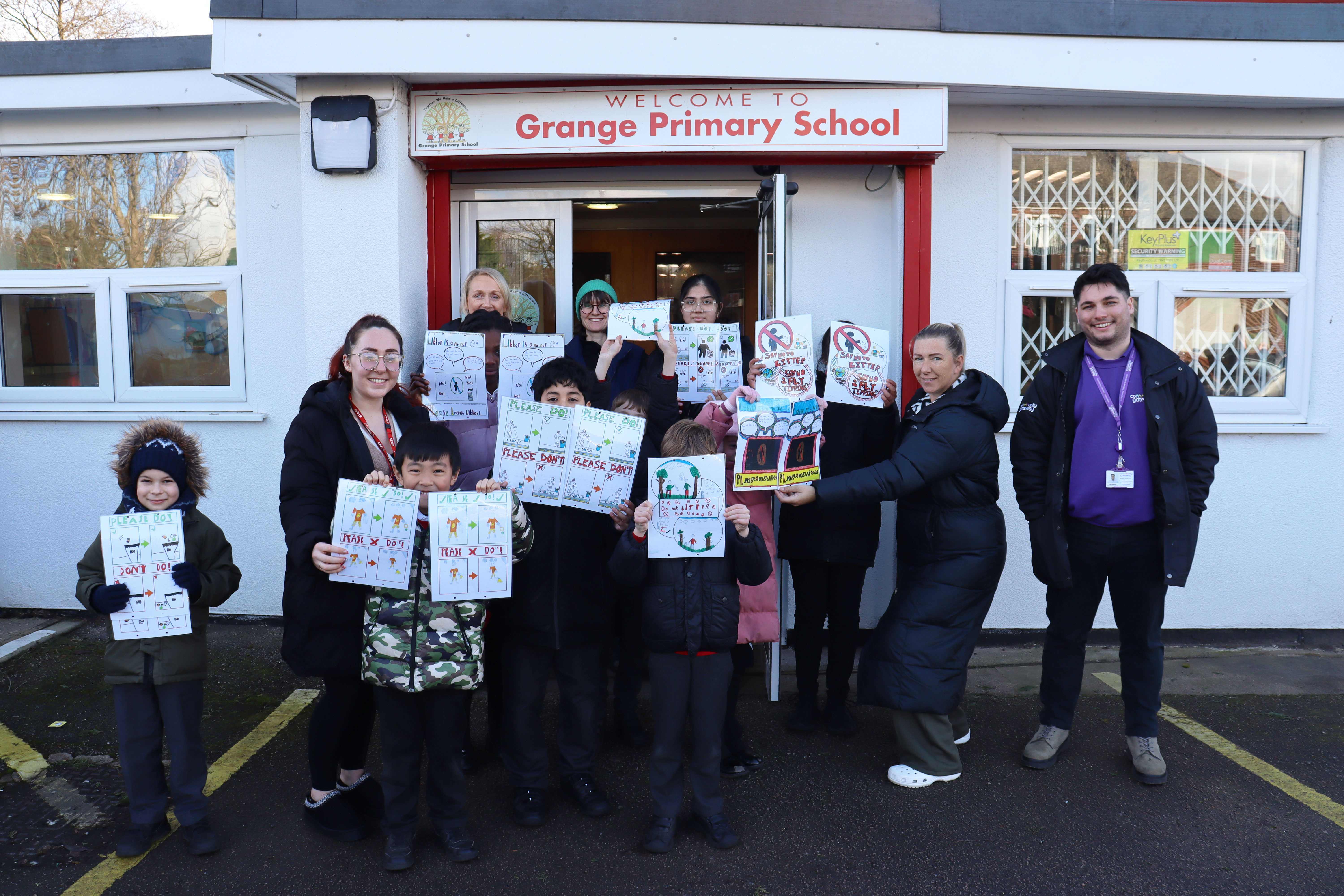 A group photo with our Engagement Team and children from Grange Primary School holding posters