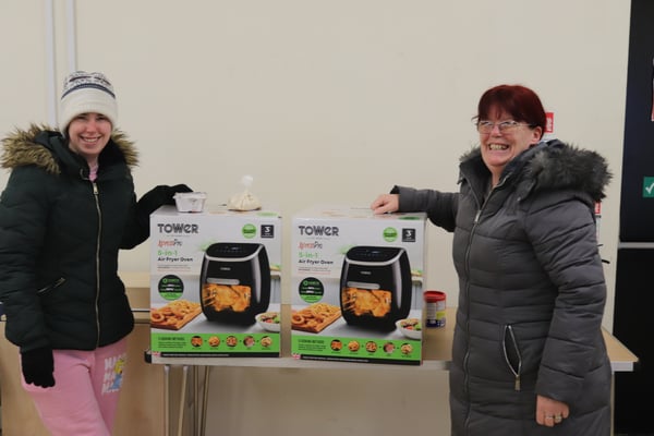 Showing two tenants collecting their air fryers after completing a community cooking course