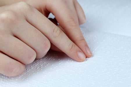 blind-woman-read-book-written-braille